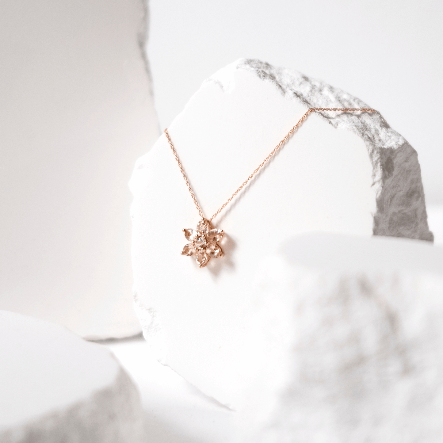 Rose gold necklace with a star-shaped pendant on a white background