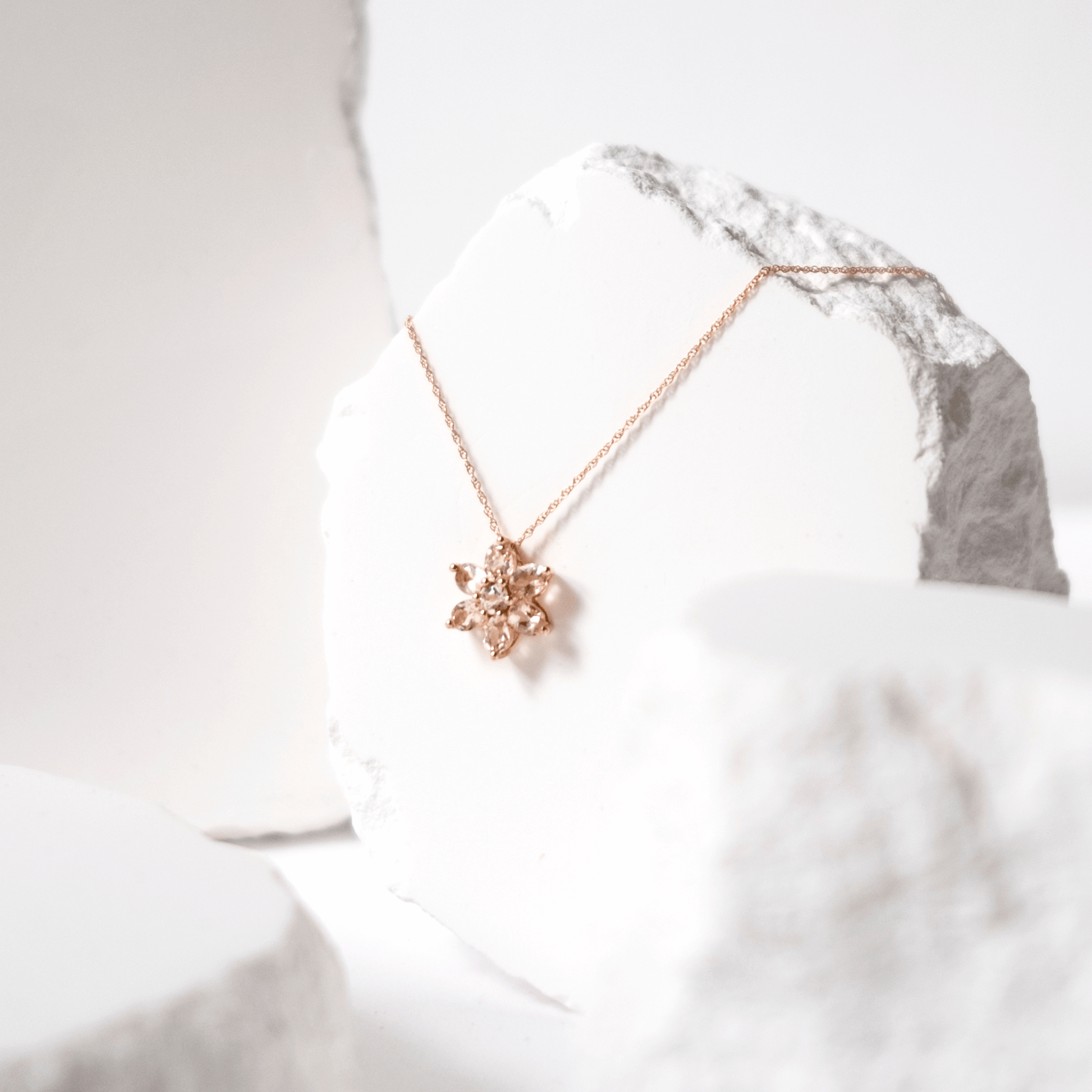 Rose gold necklace with a star-shaped pendant on a white background