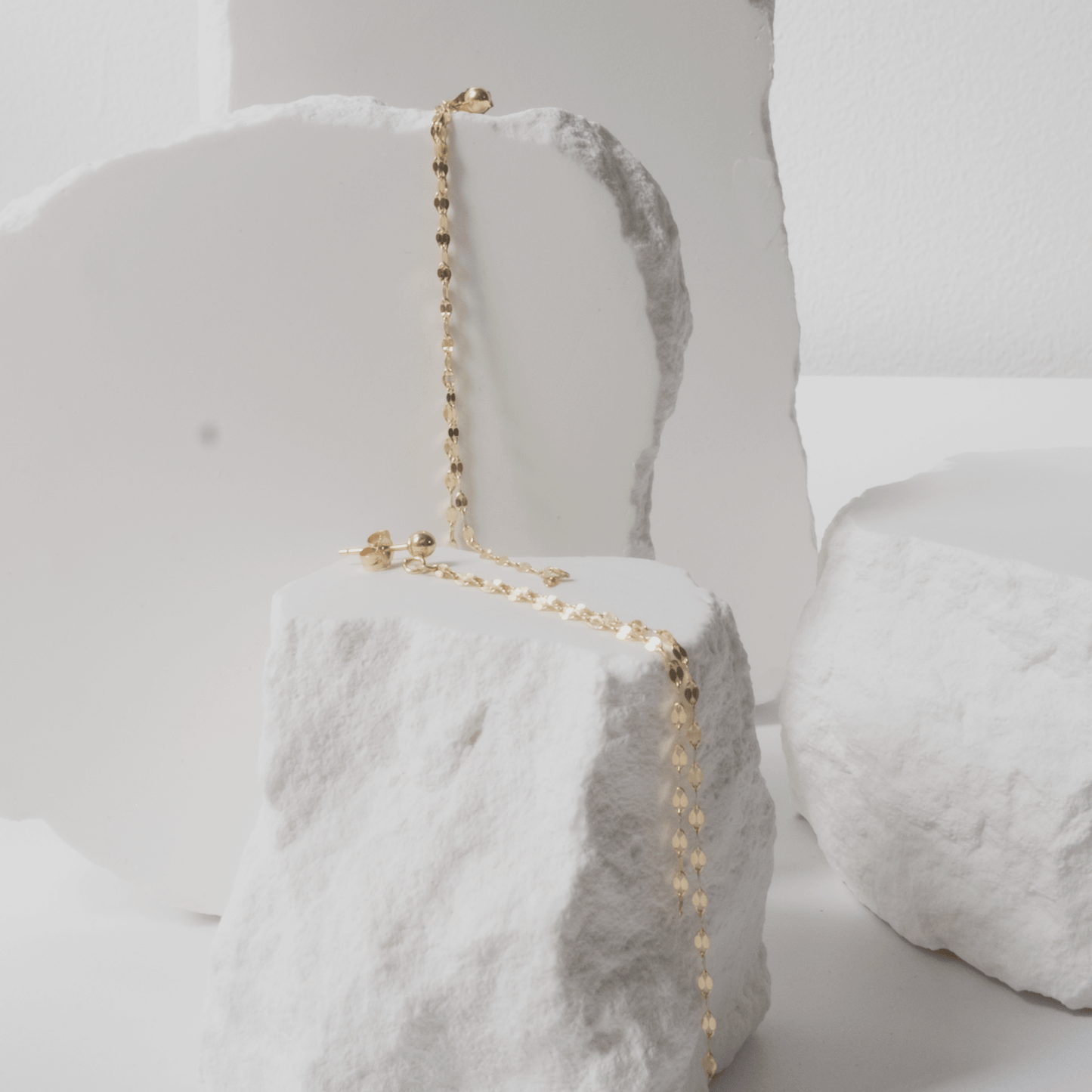Gold necklace on a white marble surface