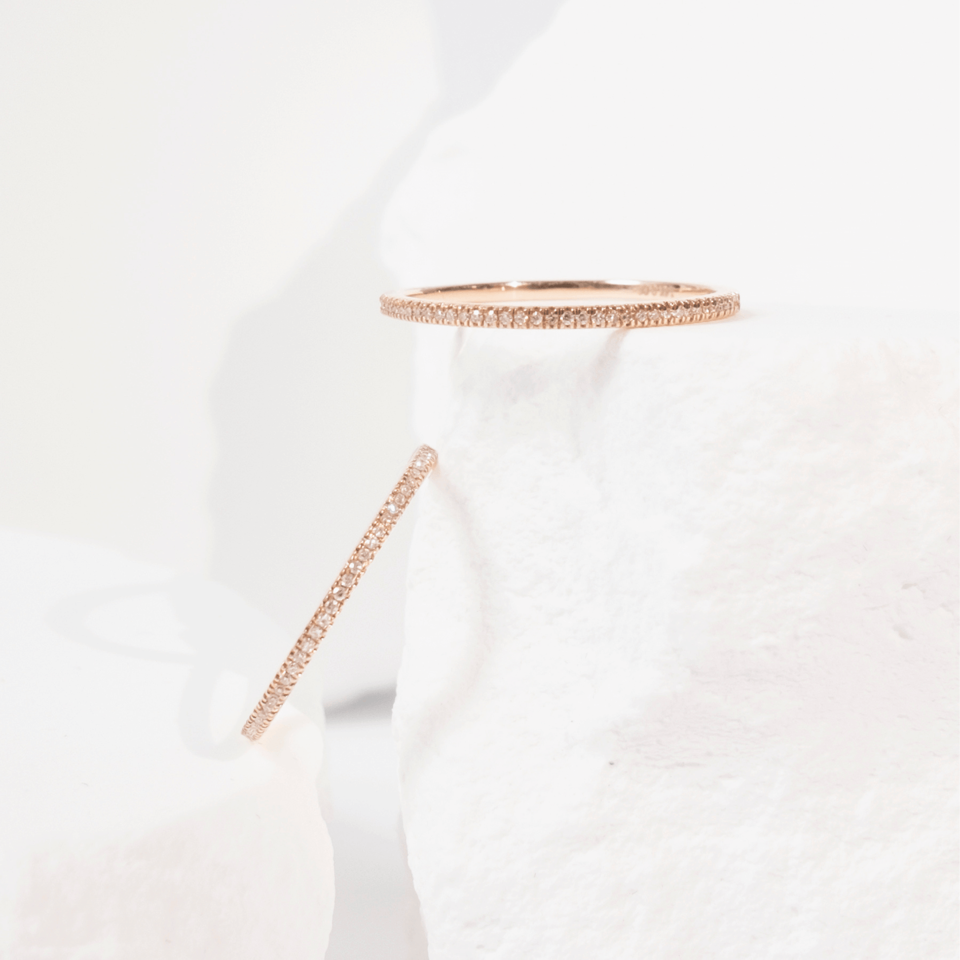 White garment with rose gold trim on a light gray background