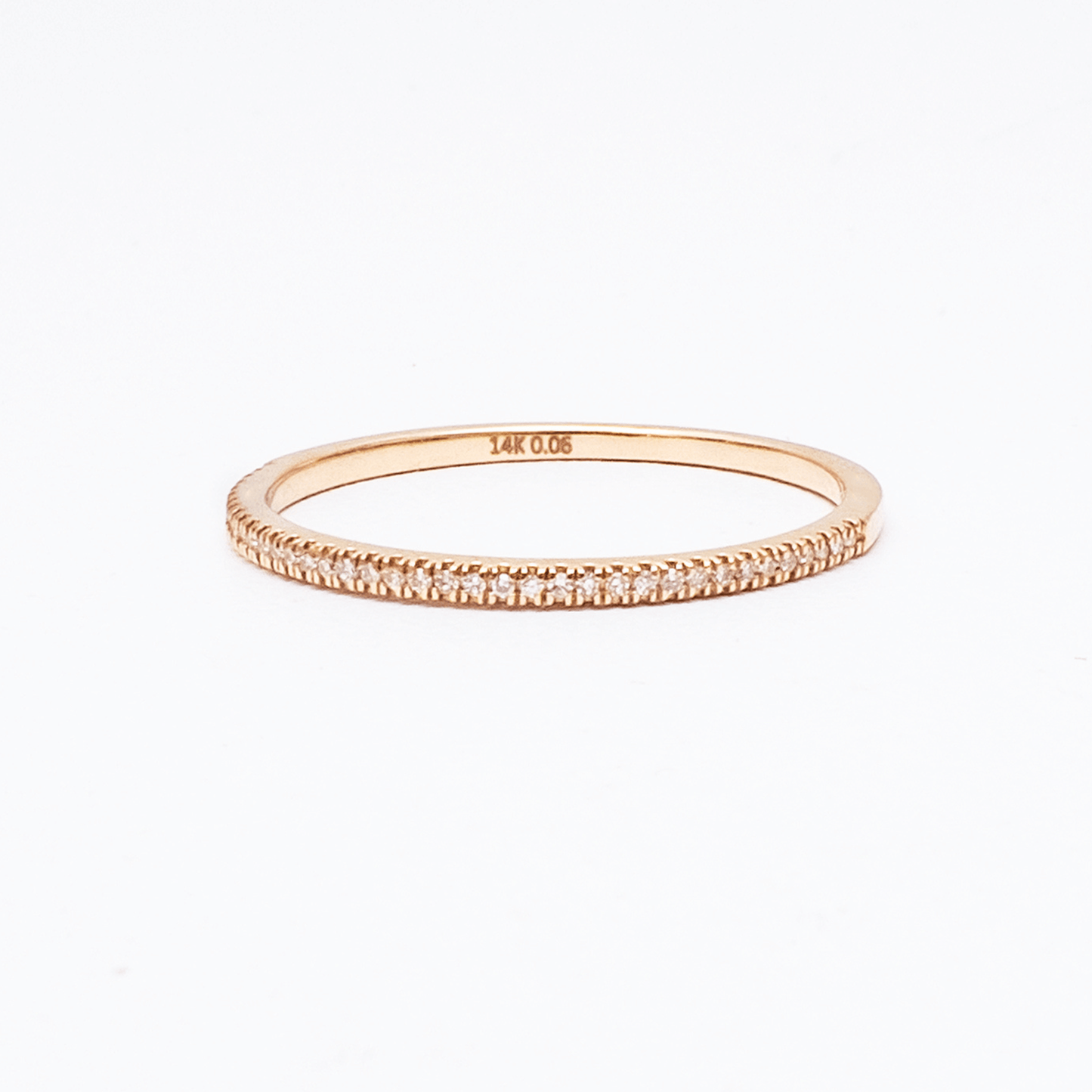 Rose gold ring with diamond accents on a white background