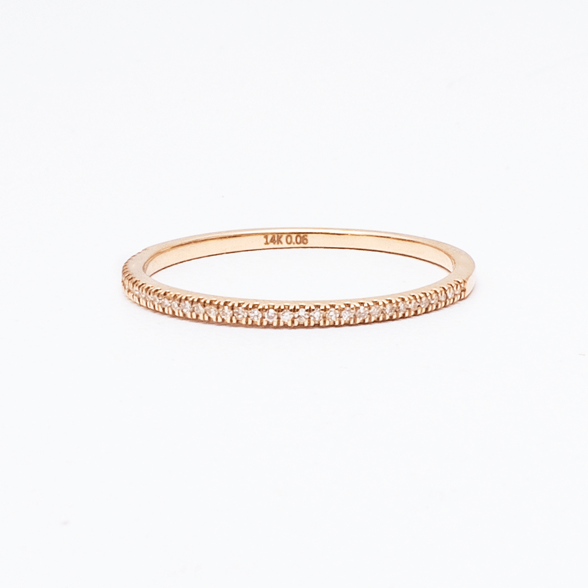 Rose gold ring with diamond accents on a white background