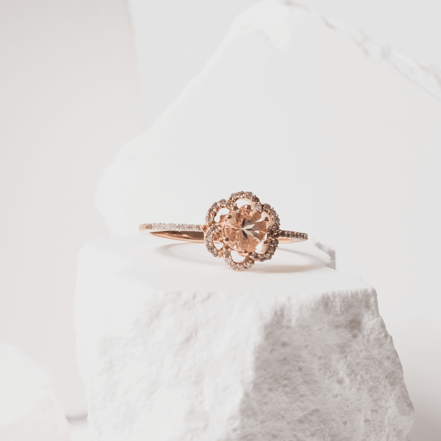 Rose gold ring with intricate design on a white background
