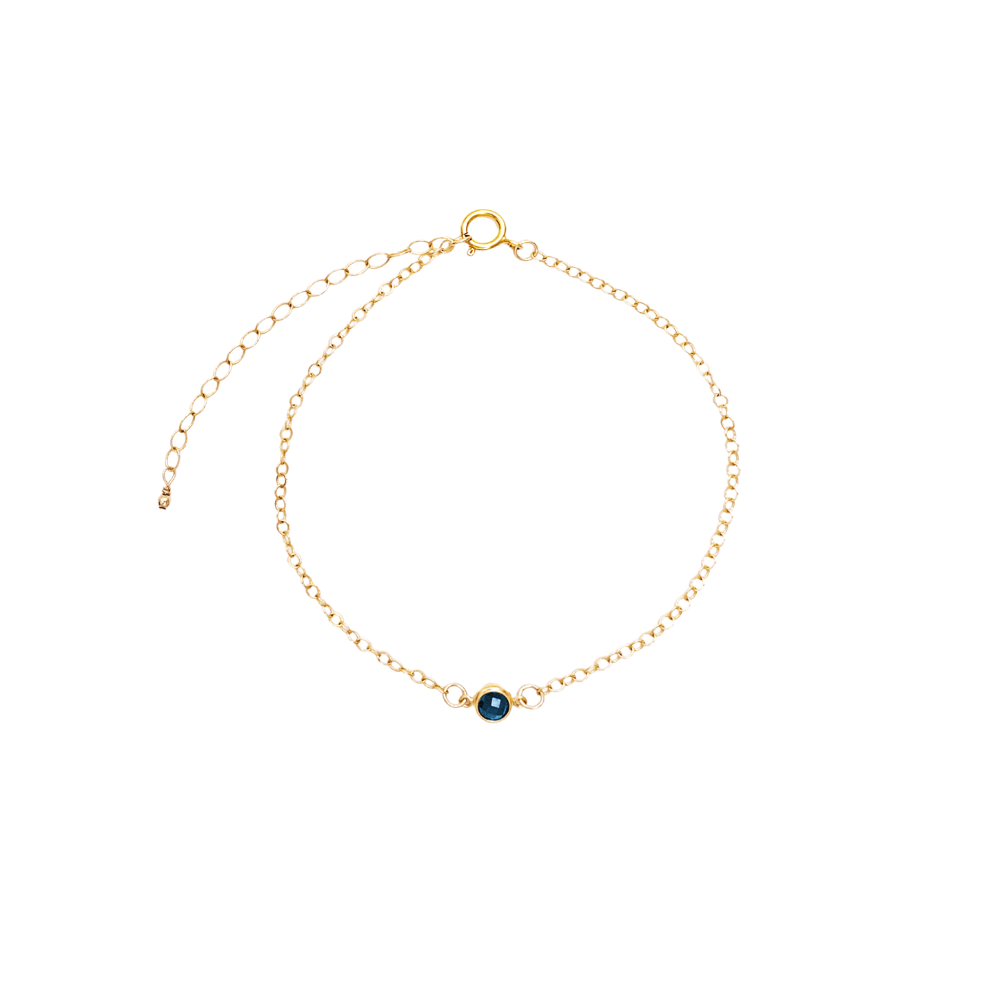 Gold bracelet with a small blue gemstone on a white background