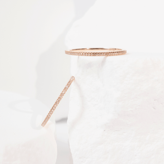 White garment with rose gold trim on a light gray background